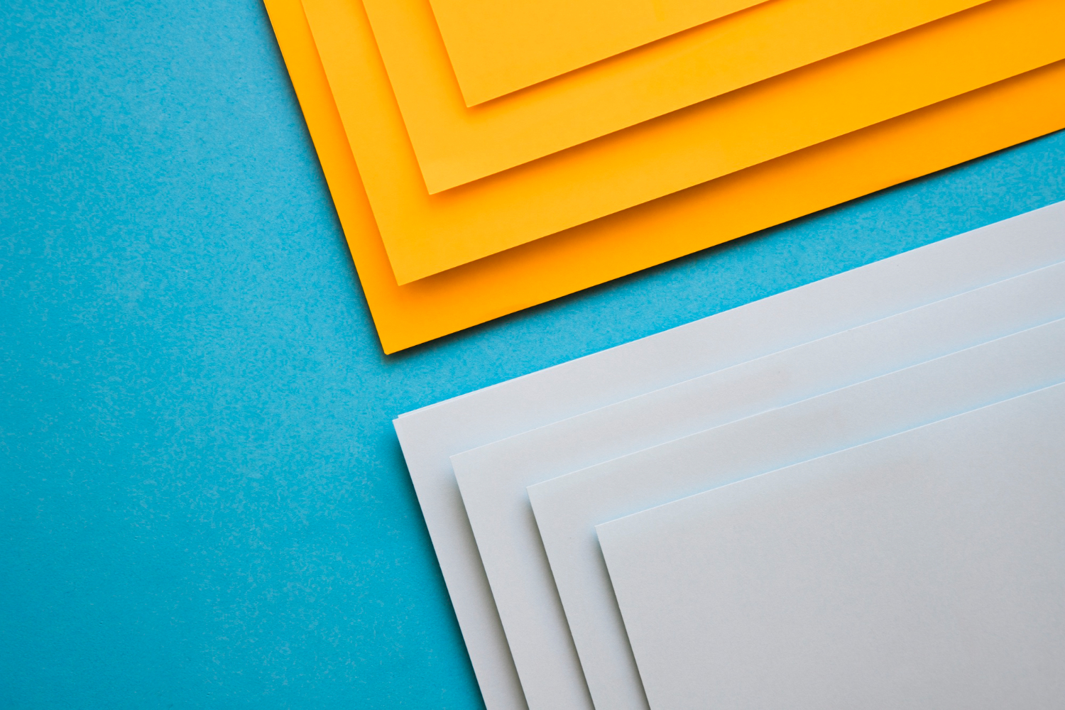 elevated-view-grey-yellow-cardboard-papers-blue-surface